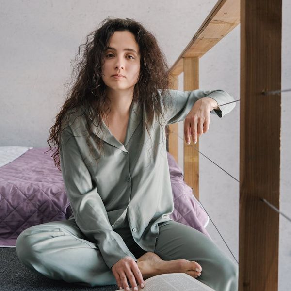 Woman meditating peacefully in a natural setting with soft light.